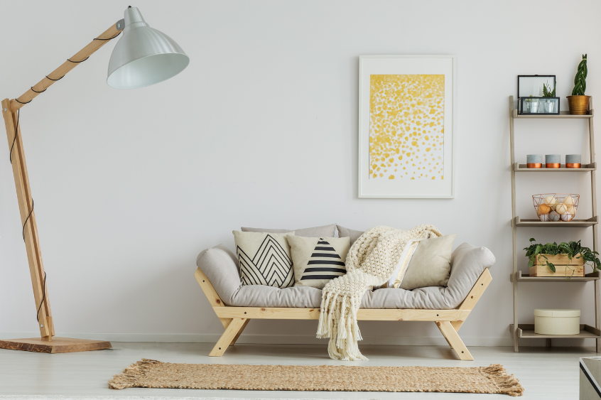 Fotografía de un salón con estantería, lámpara de pie, sofá y alfombra elaborada con cuerda de cáñamo.